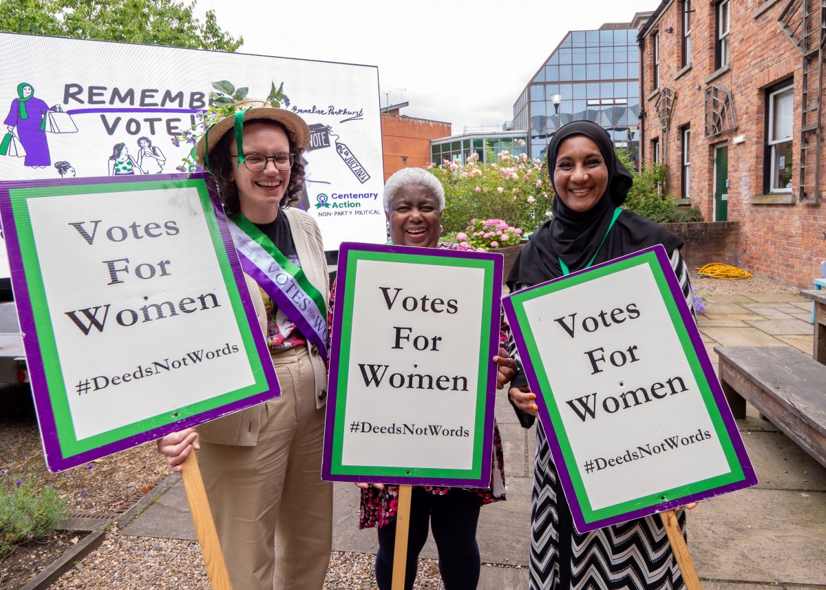 Women with vote van and Votes for Women placards
